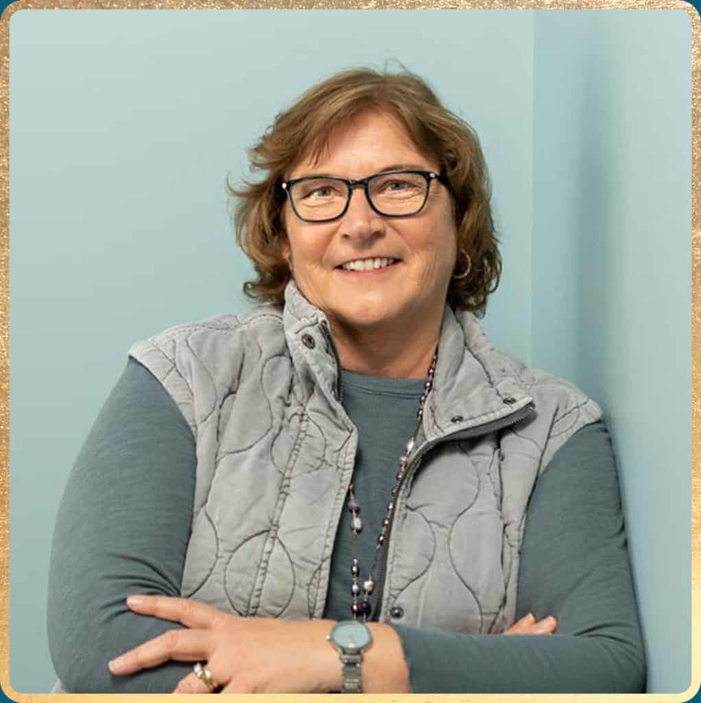 Portrait of Andrea Ferrante Business Coach in Maine standing against wall